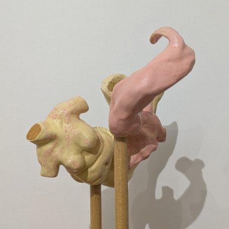 Skulptur aus geschwungenen, organisch geformten Elementen in Rosa und Beige auf Holzstangen.
